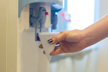 woman pressed the button of drinking water filling station