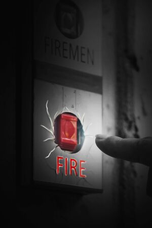 Hand of woman reaching to Fire alarm switch systemの写真素材