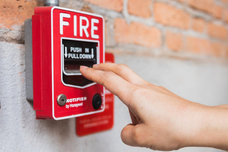 Hand of woman reaching to Fire alarm switch system