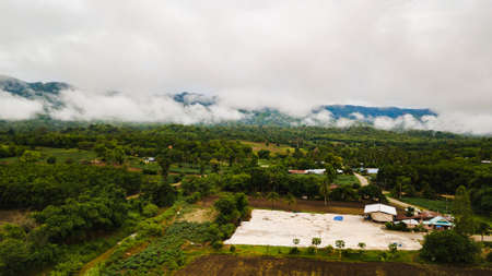 view of green field against mountain and blue sky with cloudの写真素材