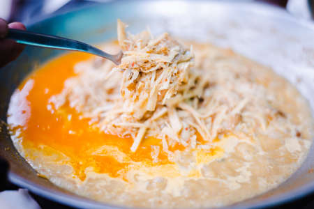 Traditional spicy curry soup of pickled bamboo shoot with chilly paste, basil and fried tofu in the pan.の写真素材