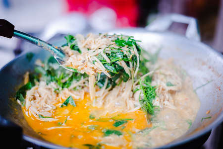 Traditional spicy curry soup of pickled bamboo shoot with chilly paste, basil and fried tofu in the pan.の写真素材