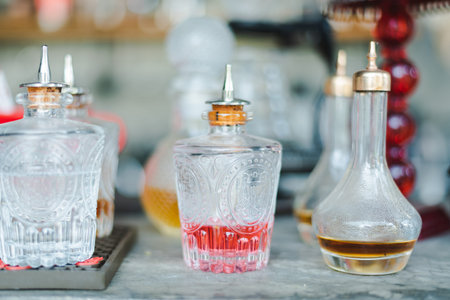 Glass bottles, vintage cut glass decanters and crystal carafes with different alcoholic drinks and...