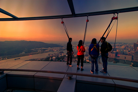 Tourists are seeing sunset and enjoy with skywalk outside Macau Tower.のeditorial素材