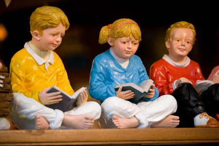 Reading, education, hobby concept. Sculpture of children sitting and reading a book together.の写真素材