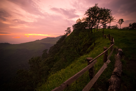 Wood fence on the cliff with beautiful sunset at Phu Soi Dao National Park, Thailand.の写真素材