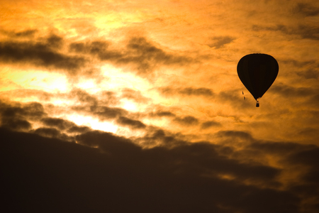 Silhouette hot air balloon flying with sunset sky.の写真素材