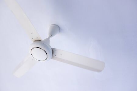 White ceiling fan on a white ceiling.の写真素材
