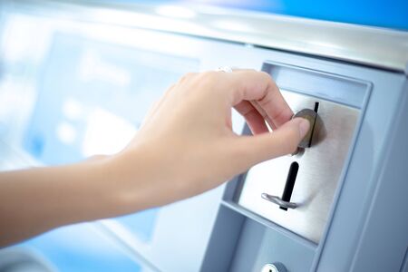 Coin slot of coin laundry vending machine, coin inserting by hand.の写真素材