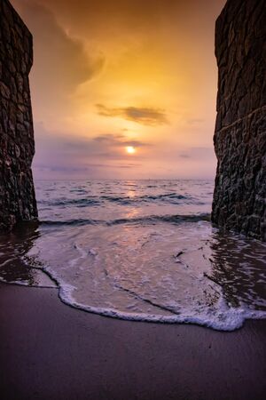 Sunrise view at the beach with two sides of brick wall.の写真素材