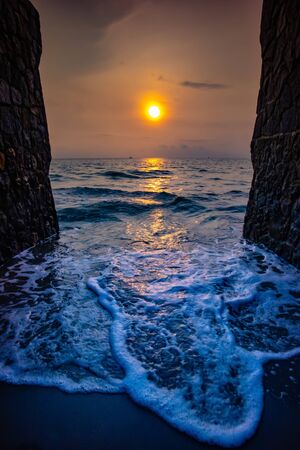 Sunrise view at the beach with two sides of brick wall.の写真素材