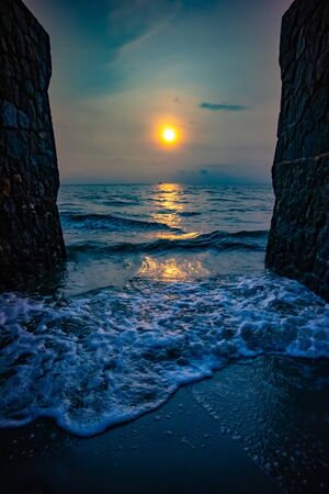 Sunrise view at the beach with two sides of brick wall.の写真素材