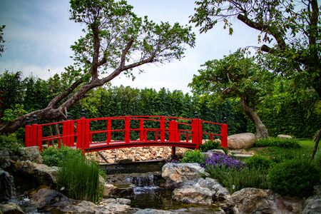 The japanese style of red wooden bridge in the garden.の写真素材
