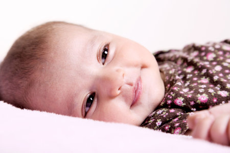 Beuty baby looking over white blanket. Image 