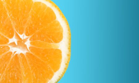 Orange slice over blue background. Isolated imageの写真素材