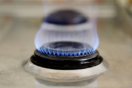 Blue flame of an old gas stove. Side view
