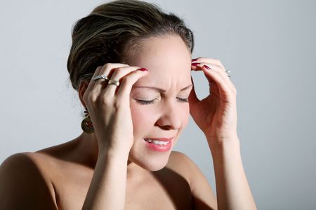 Young woman with headache in gray backgroundの写真素材