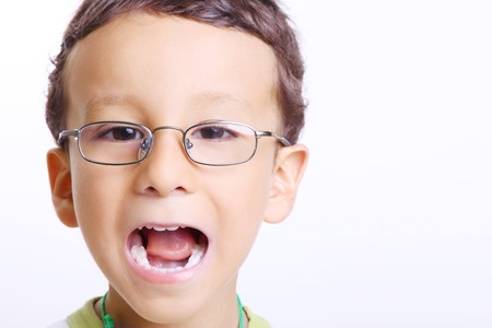 Child smiling with his mouth open and looking at the cameraの写真素材