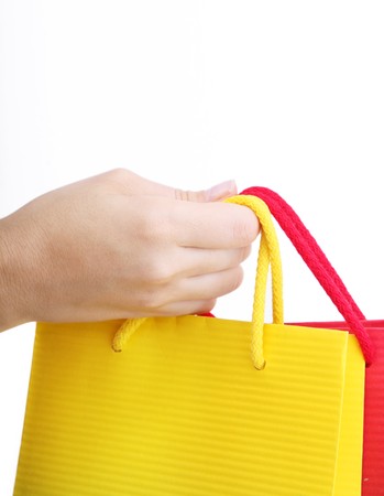 Hand holding a shopping bag over white backgroundの写真素材
