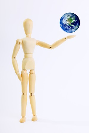 Wooden doll with planet on his handの写真素材