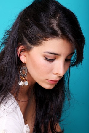 Young woman looking down over blue backgroundの写真素材