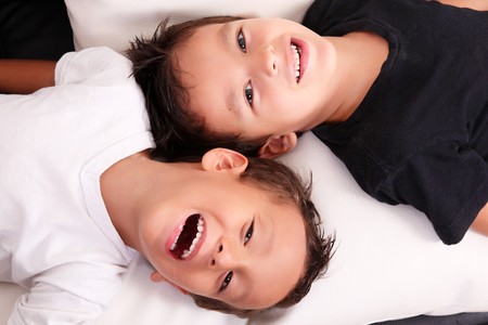Two boys smiling and looking at the camera over white and black backgroundの写真素材