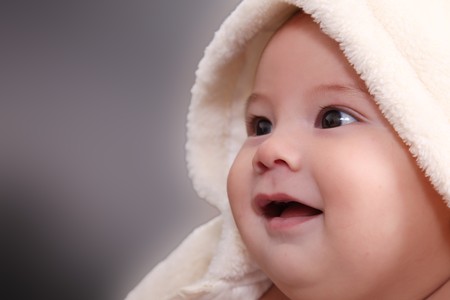 Face of a baby with a blanket over his head, smilingの写真素材