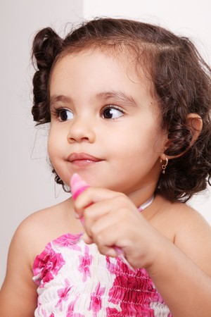 Two year old girl playing with lipstickの写真素材