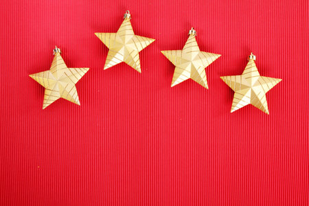 Four gold Christmas stars  over red background