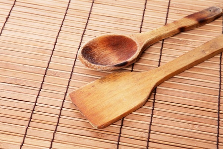 Wooden spoons used and burned over bamboo sticks tableの写真素材