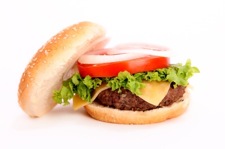 open hamburger with onion,tomato,lettuce,cheese,meat and bread over white backgroundの写真素材