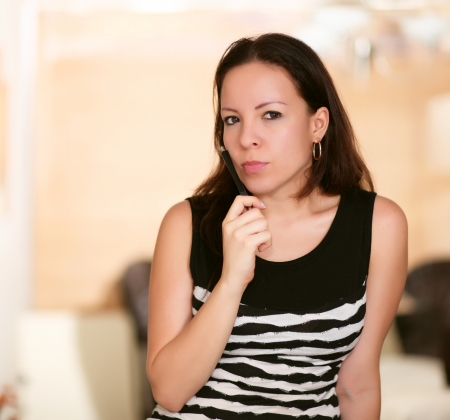 seriously thinking woman with a pen in hand の写真素材