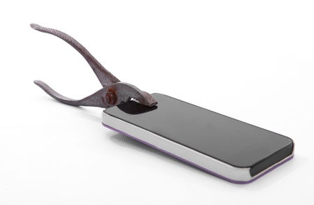 Modern cell with a rusty pliers over white backgroundの写真素材