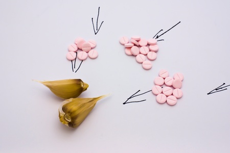 Garlic and anti-virus tablets on a light background
