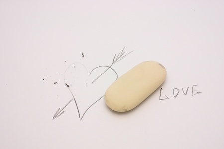 Rubber and partially erased drawn heart on a paperの写真素材