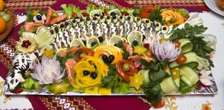 Stuffed Pike on a platter with vegetables on the table.の写真素材