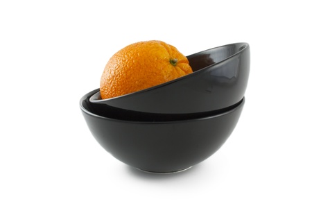 Orange and two ceramic black plates over white backgroundの写真素材
