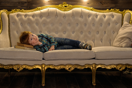 Red-haired boy is lying on the couch. Dreamer. Vintage. Fairytale Photographyの写真素材