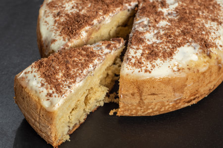 Charlotte with custard, grated chocolate, one piece cut off, on a dark backgroundの写真素材