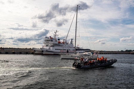 Hel, Pomeranian, Poland - 07.25.2023: Ships in the port town of Hel, one is moored, the other two are moving towards each other on a summer day.のeditorial素材