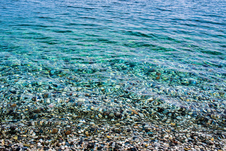 Transparent clean water on a pebble beach in the Mediterranean Sea, close-up. Kemer, Turkeyの写真素材