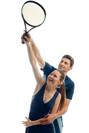 Tennis coach shows basics to his trainee. Woman and man holding a racquet, sharpening movement, improving skills.の写真素材