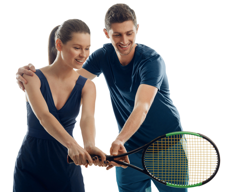 Coach teaches woman to play tennis and hold a racket. Trust and positive emotion during training.の写真素材