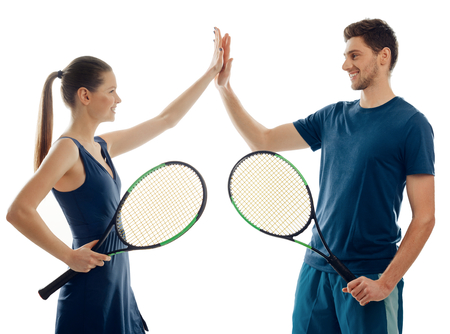Players giving high five after a match. Fit woman and man playing tennis together. Friendly atmosphere and fun.の写真素材