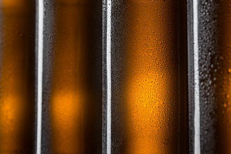 Four brown bottles in macro view. Cold glass with droplets of water. Nice desktop wallpapers for beer fans.の写真素材