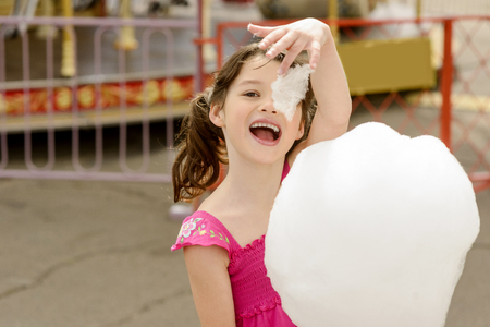 Little girl plays with the cotton candyの写真素材
