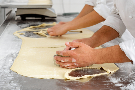 Workers cutting dough piecesの写真素材