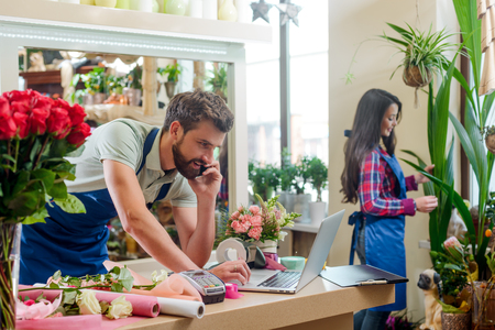 Male florist talking with clientの写真素材