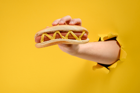 Hand taking a hot dogの写真素材