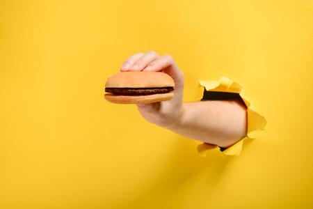 Hand holding a hamburgerの写真素材